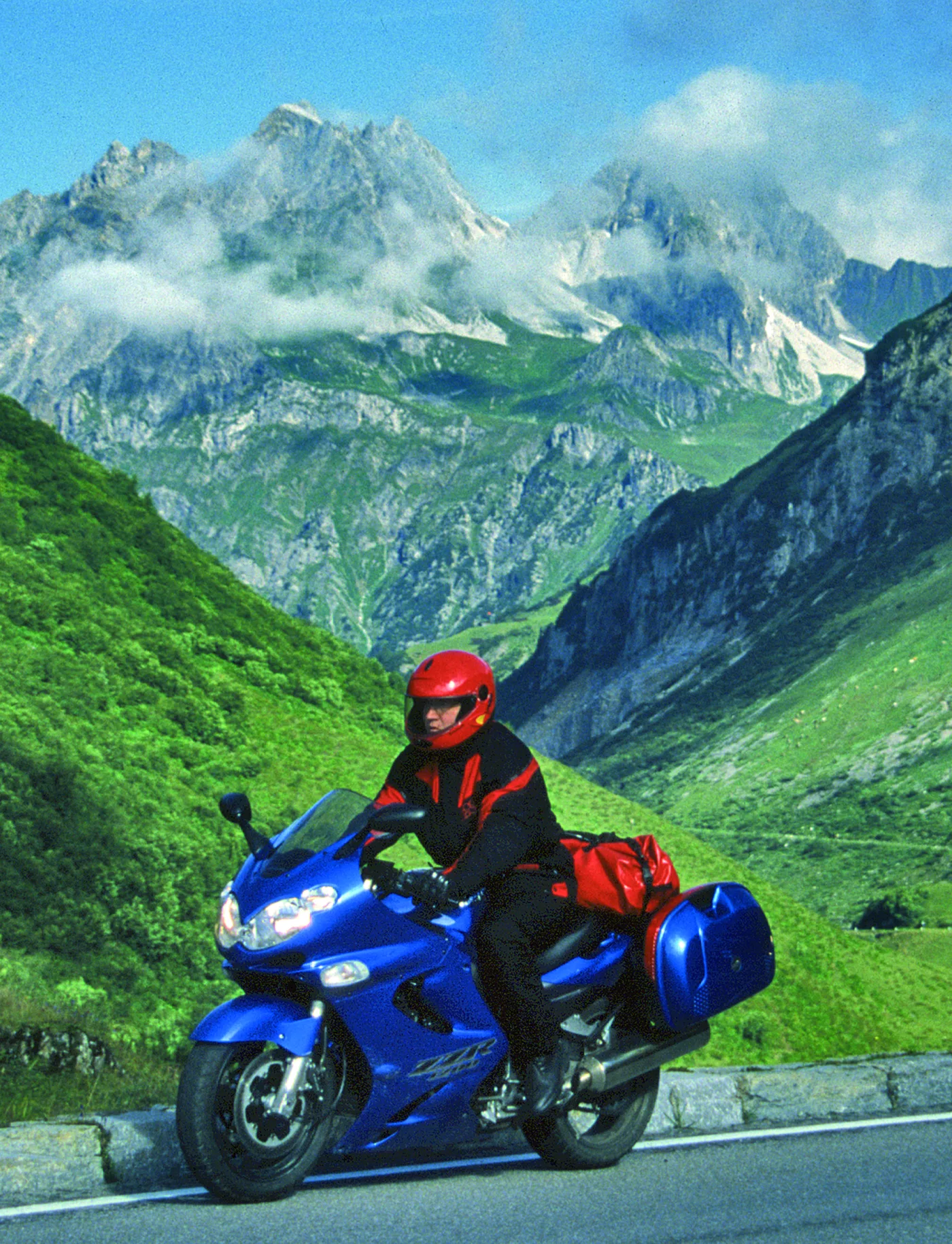 Motorrad auf der Passstraße vor schneebedeckten Gipfeln